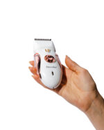 Set de depilación femenina ElectroBell Pro modelo EB-101 Lady Groomer en color rosado pastel metalizado. El dispositivo principal se muestra de frente junto a sus 5 cabezales intercambiables para rostro, cejas, bikini y cuerpo. Al fondo se encuentra su empaque original blanco y rosado con la fotografía del producto y el texto 'Lady Groomer' de la línea Professional Beauty Tools.