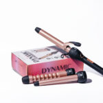 Pinza rizadora de cabello profesional marca ElectroBell Pro modelo EB-007 de la línea Dynamic en color negro mate con detalles cromados. La pinza cilíndrica se muestra de perfil junto a su empaque original de lujo en color negro, donde destacan las especificaciones técnicas en dorado: '450°F' y 'TITANIUM Plates'.